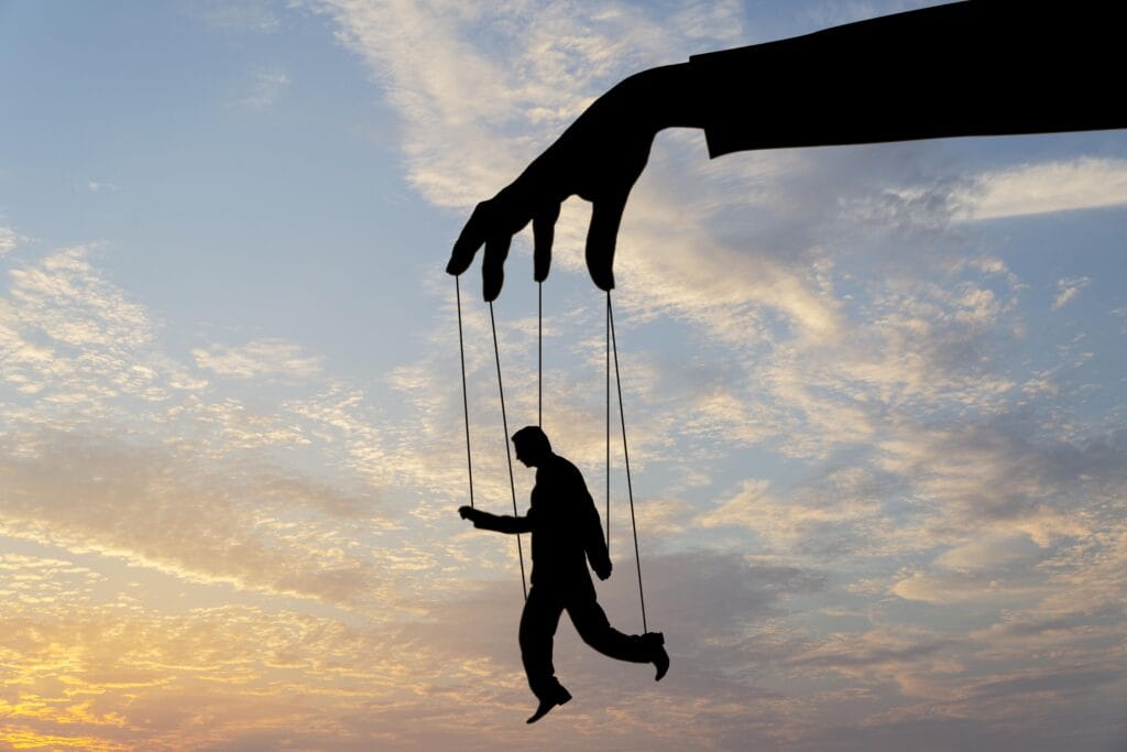 Un hombre siendo manejado como una marioneta