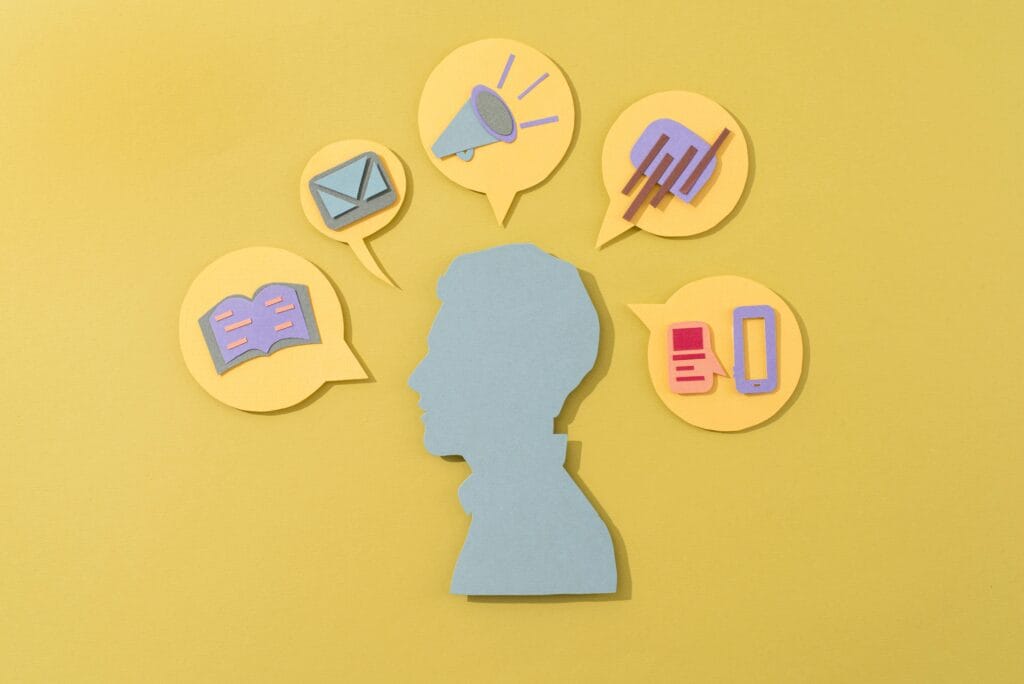 Un busto rodeado por distintos medios de comunicación ejemplifica la importancia de saber qué es la propaganda