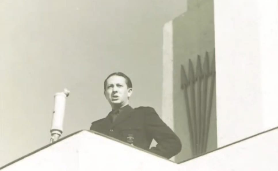 Dionisio Ridruejo da un discurso en medio de una impresionante escenografía