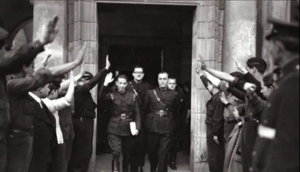 Dionisio Ridruejo saluda a varios ciudadanos al salir de un edificio