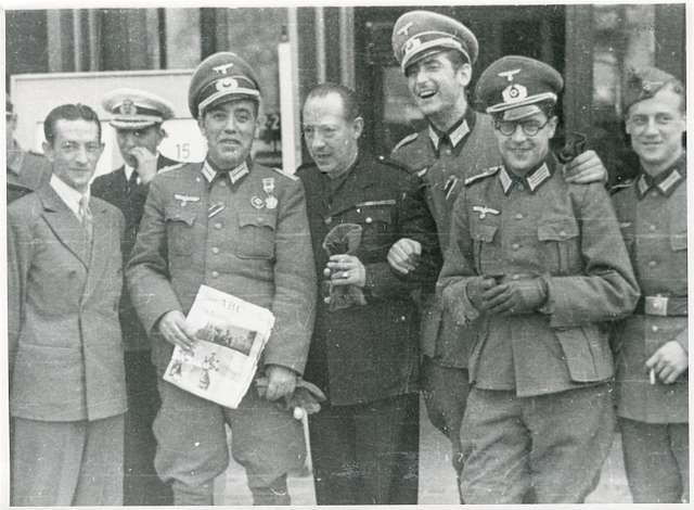 ionisio Ridruejo, de civil, Junto a mandos militares españoles vestidos con uniformes  de la Wehrmacht en una estación de tren