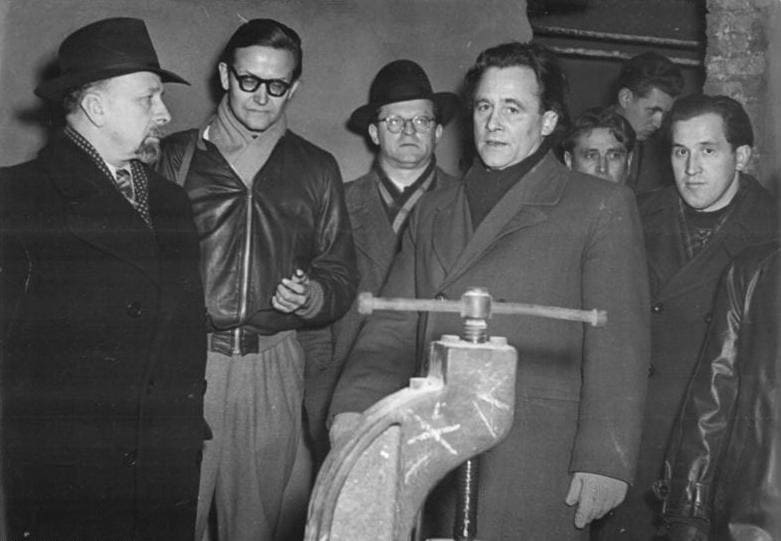 Karl-Eduard von Schnitzler con gafas y chaqueta de cuero junto a Walter Ulbricht en las obras del rascacielos de la Weberwiese en Berlín.