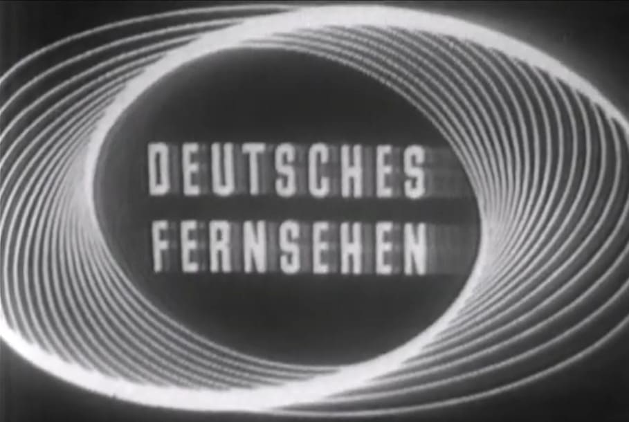 Logotipo antiguo en blanco y negro de Deutsches Fernsehen enmarcado por espirales elípticas concéntricas sobre un fondo oscuro.