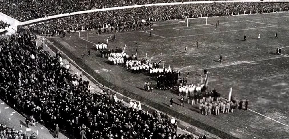 Vista general en blanco y negro de las delegaciones desfilando por el césped de un estadio abarrotado en el mundial de 1934.