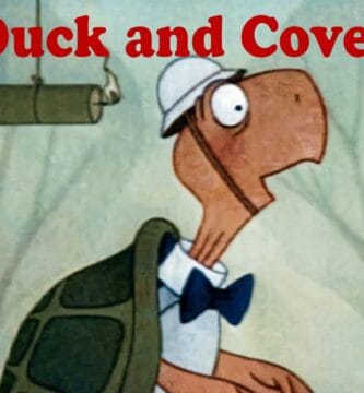 Bert la tortuga animada con casco y pajarita mira con sorpresa un cartucho de dinamita encendido bajo el texto rojo Duck and Cover.