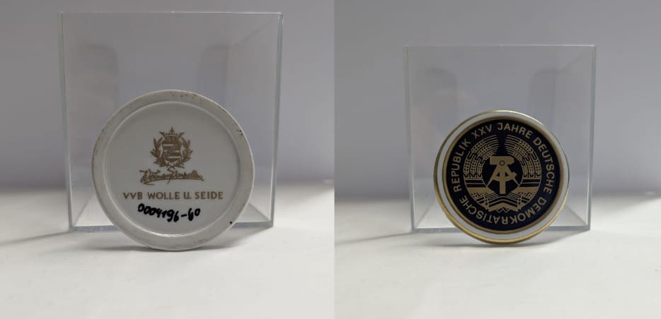Platos de porcelana de la RDA por el 25 aniversario con escudo nacional de martillo y compas sobre fondo negro y dorado.