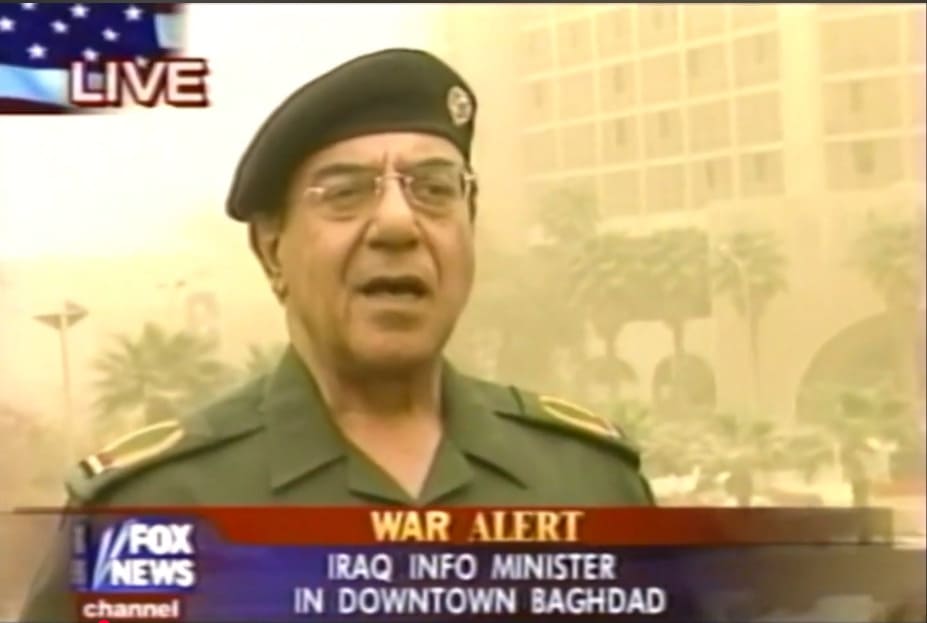 Retransmisión de Fox News en Bagdad mostrando a Mohamed Said al-Sahaf hablando al aire libre en un ambiente cubierto de polvo.