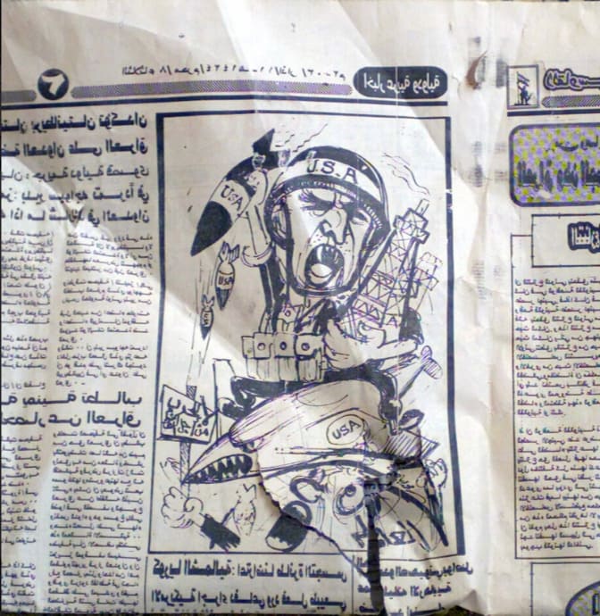 Periódico iraquí con caricatura de soldado de Estados Unidos con casco USA que sujeta un misil y una torre de extracción de petróleo.