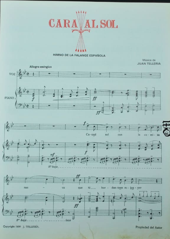 : Partitura musical en papel del himno Cara al Sol de la Falange Española con notas para voz y piano compuestas por Juan Tellería.