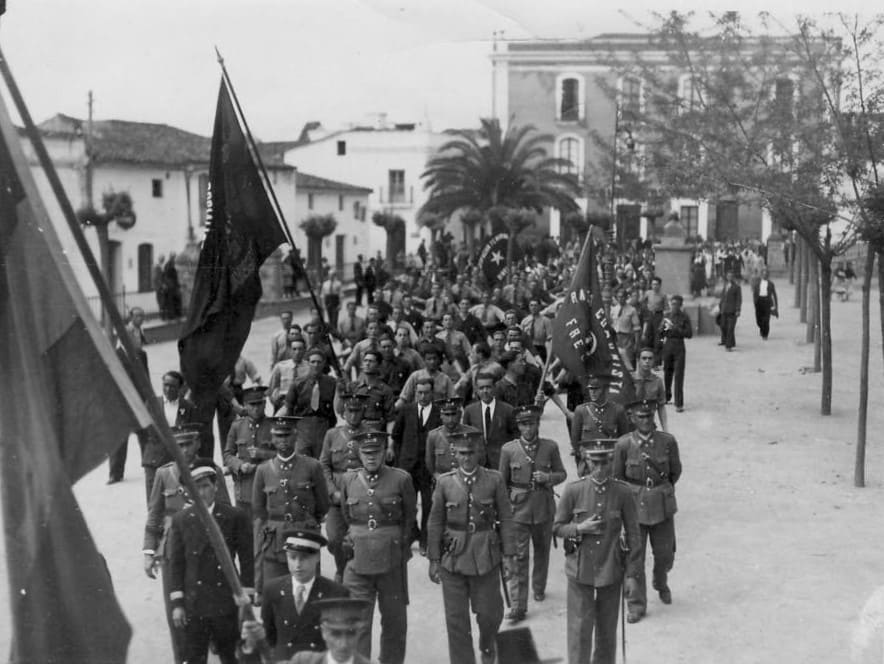 Fotografía histórica en blanco y negro de manifestación del Frente Popular en 1936 con banderas comunistas y La Internacional.