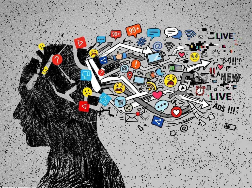 Silueta de cabeza humana en blanco y negro saturada de iconos de redes sociales, alertas y mensajes en color saliendo de la mente.